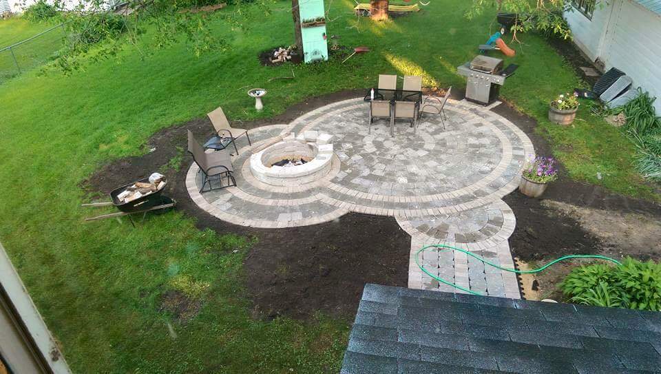 Custom circular paver patio with a stone fire pit built by Mowers Landscaping
